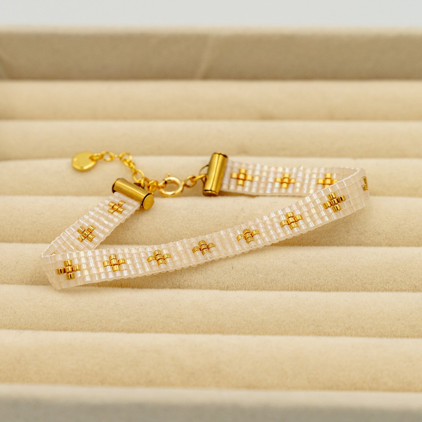 Håndsyet armbånd med forgyldte guldperler i changerende beige, fra siden