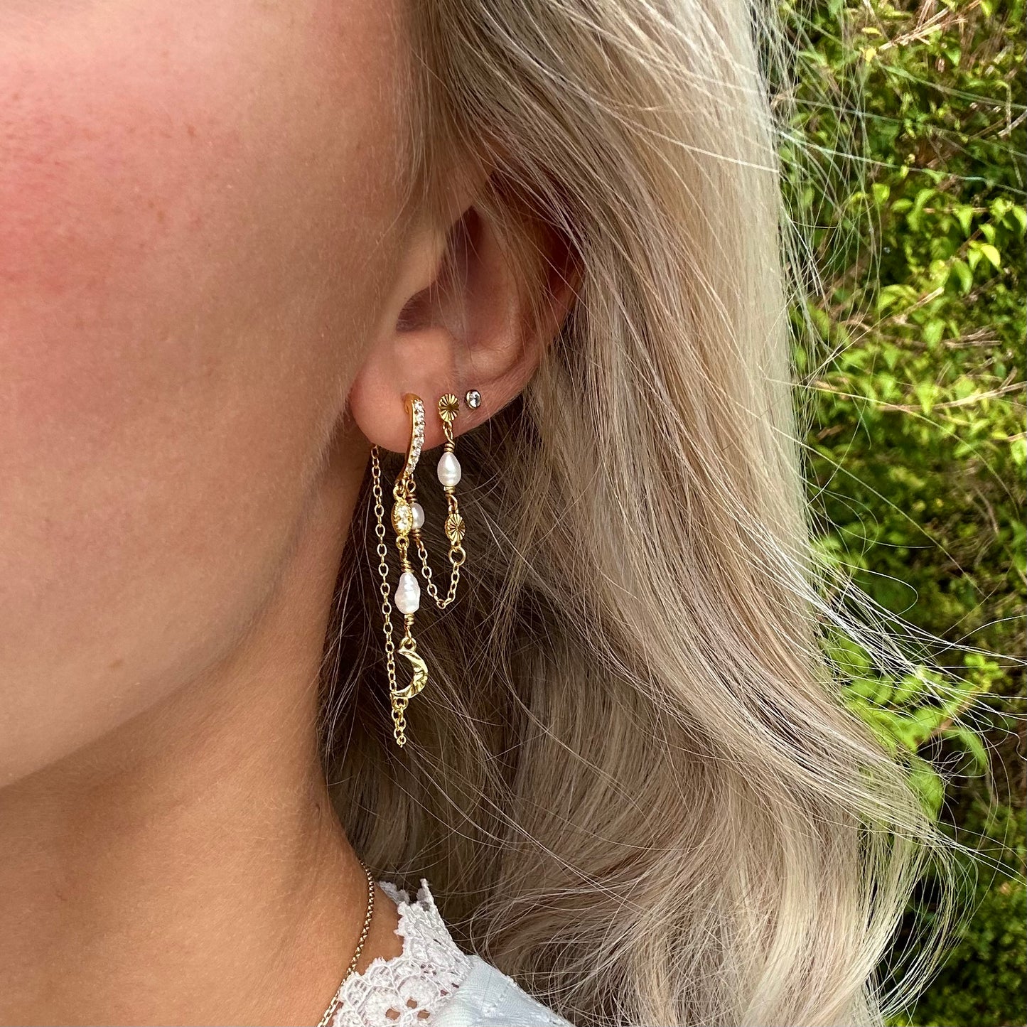 Guldbelagte øreringe ørestikker (behind the ear) med måner, zirkoner og måner i banket blankt design, på model